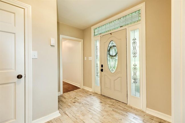 This welcoming foyer sets the tone for the home, featuring high ceilings, abundant natural light. | Image 11