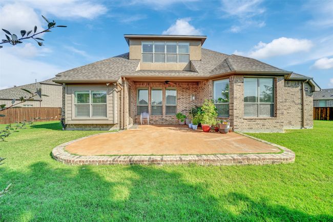 Back of house with a patio area, roof with shingles, and brick siding | Image 38