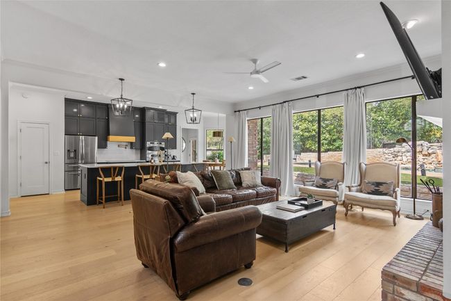 Living room with light wood-style floors, visible vents, a wealth of natural light, and ceiling fan | Image 7