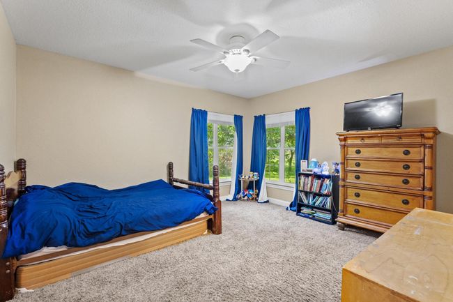 Bedroom with a ceiling fan, baseboards, and carpet | Image 26