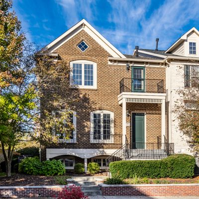 Welcome to 220 Manchester Dr, a stunning brick-front property with timeless curb appeal. Nestled in a serene neighborhood, this home boasts classic architecture, lush landscaping, and a welcoming front porch for perfect afternoons in the sun. | Image 1