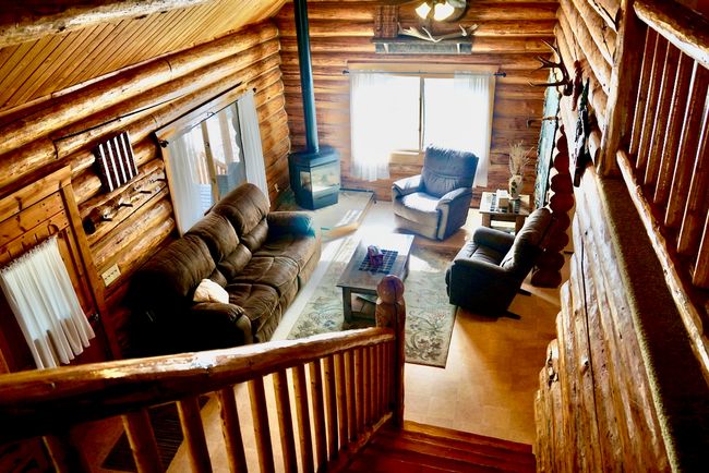 Living area with log walls, a wood stove, and wood-type flooring | Image 41