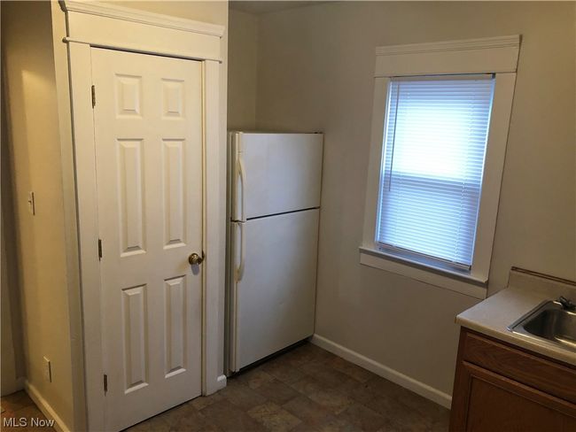 Kitchen featuring sink, white refrigerator, and dark tile flooring | Image 8