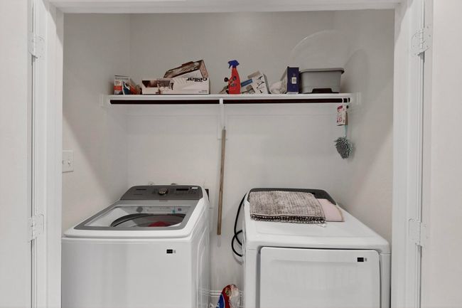 Laundry area featuring washing machine and clothes dryer | Image 31