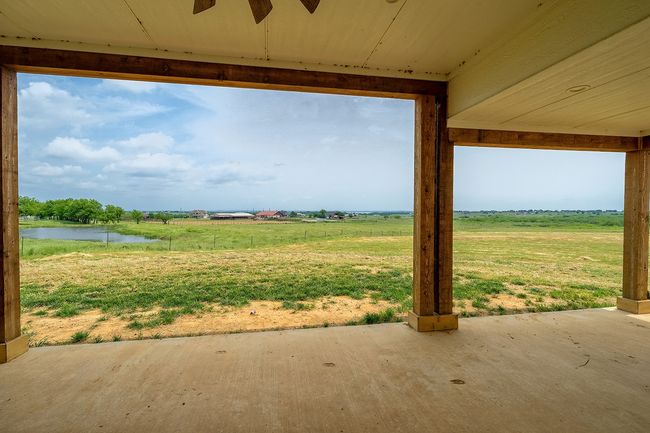 View of yard with a water view, a patio, a ceiling fan, and a rural view | Image 38