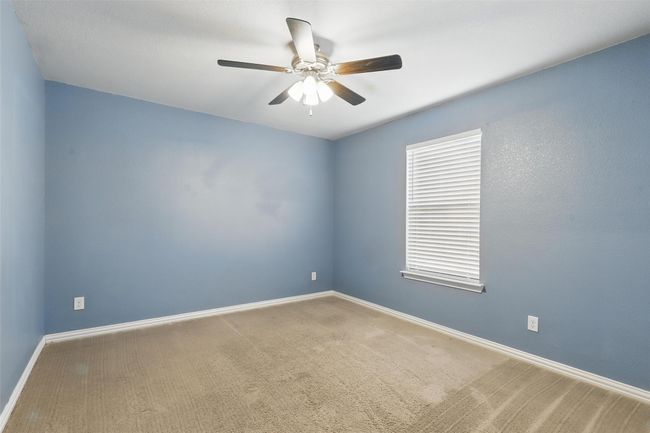 Empty room with ceiling fan, carpet floors, and baseboards | Image 21