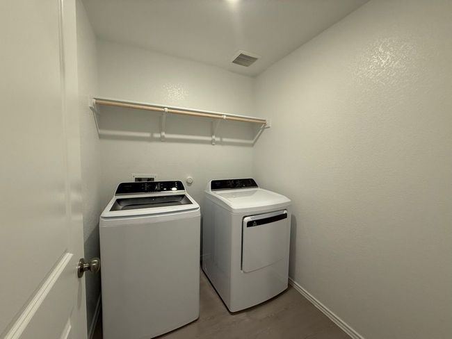 Laundry area featuring washing machine and dryer, light wood-style floors, and baseboards | Image 15