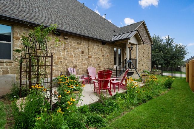 Rear view of property with stone siding, roof with shingles, a standing seam roof, a patio, and a metal roof | Image 37