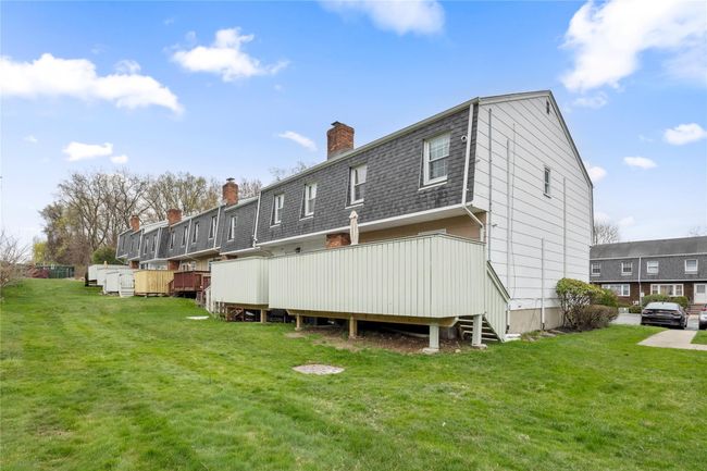 Back of house with a shingled roof, a chimney, and a yard | Image 46
