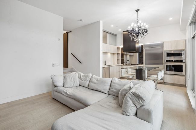 Living area featuring stairs, a chandelier, baseboards, light wood-style floors, and recessed lighting | Image 5