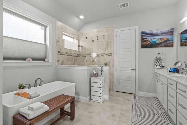 Bathroom featuring walk in shower, a freestanding bath, vanity, recessed lighting, and tile patterned floors | Image 15