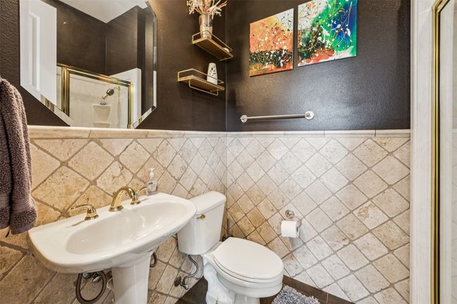 Full bath featuring a stall shower, a wainscoted wall, and a textured wall | Image 19