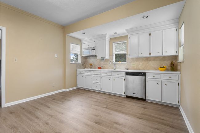 Kitchen with dishwasher, white cabinets & backsplash | Image 9