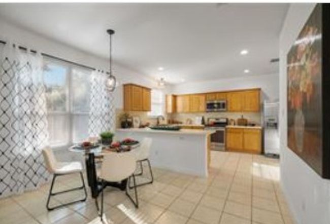 Kitchen with a wealth of natural light, a peninsula, appliances with stainless steel finishes, and brown cabinets | Image 9
