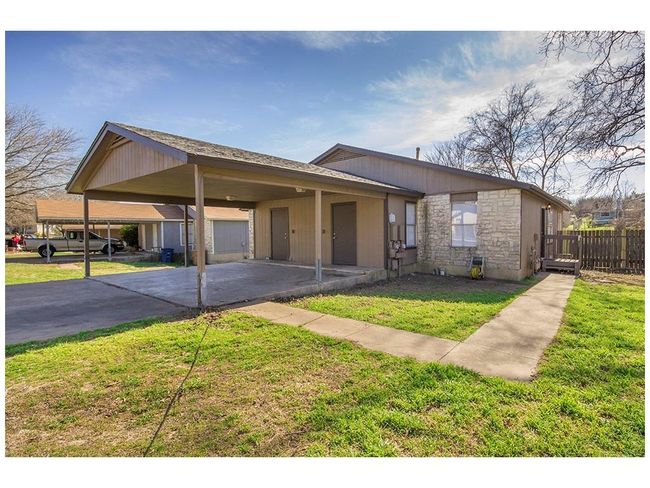 View of front of property with driveway, fence, a front yard, and a carport | Image 13