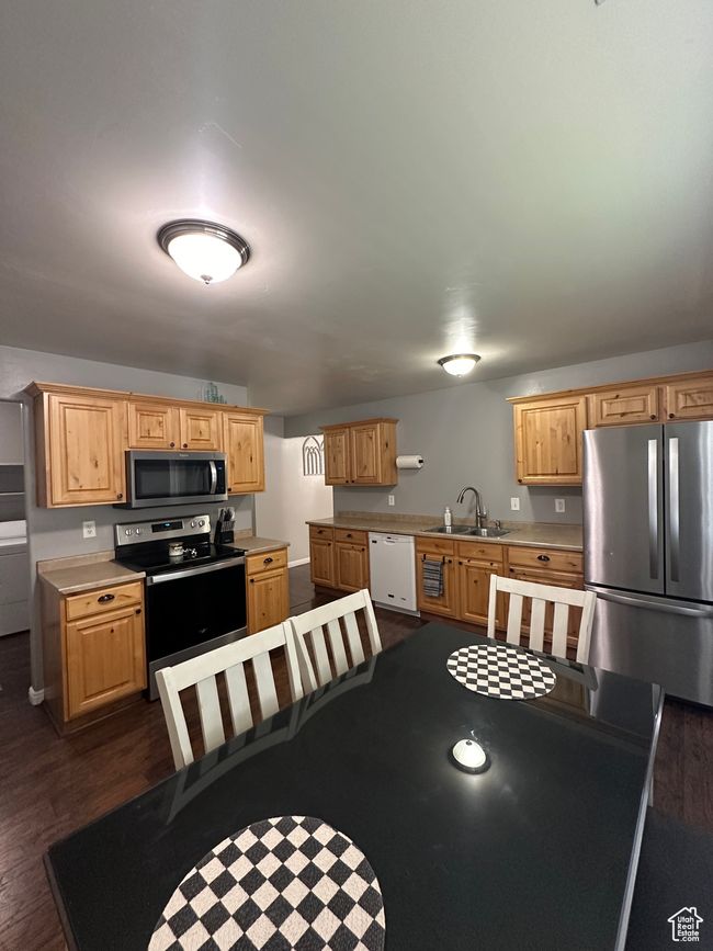 Kitchen featuring light countertops, light brown cabinets, a sink, appliances with stainless steel finishes, and dark wood-style flooring | Image 9