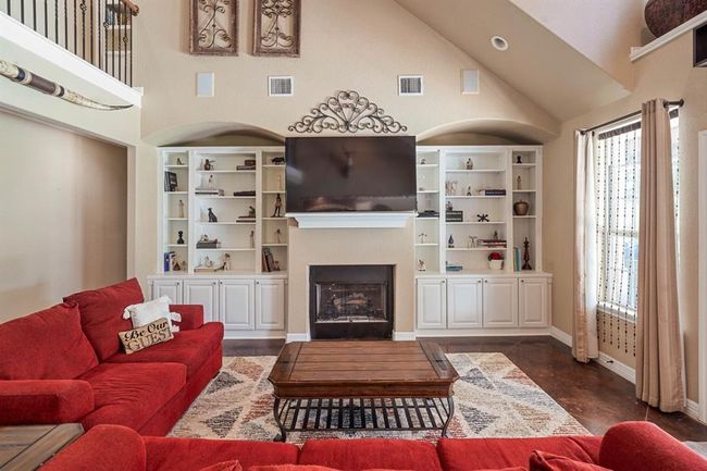 Built in shelves and double sided fireplace frame the living room. | Image 11