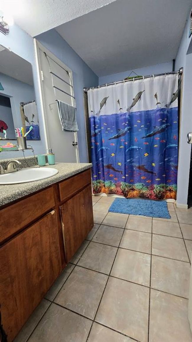 Bathroom connects to hall and to Bedroom 1. | Image 10