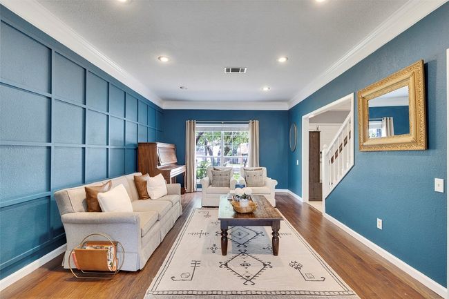 Living area with ornamental molding, wood finished floors, stairway, baseboards, and recessed lighting | Image 5