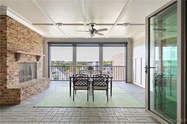 Unfurnished dining area featuring brick floor, a brick fireplace, ceiling fan, and ornamental molding | Image 30