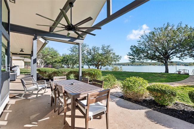 View of patio / terrace with ceiling fan, outdoor dining area, and a water view | Image 11