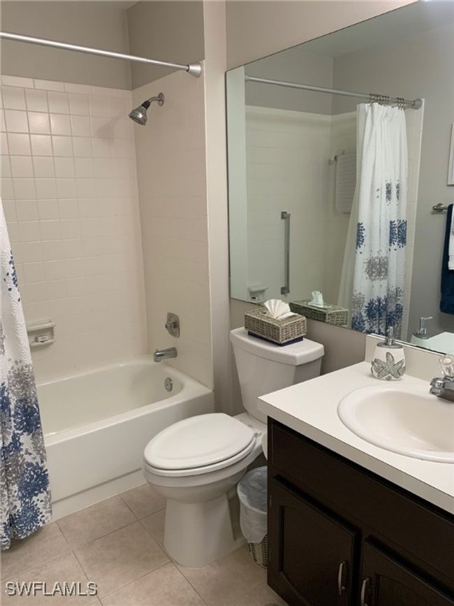 Bathroom with vanity, shower / bath combo with shower curtain, and tile patterned floors | Image 19