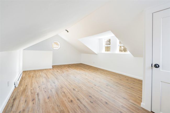 Bonus room featuring baseboards, wood finished floors, lofted ceiling, and a baseboard radiator | Image 17