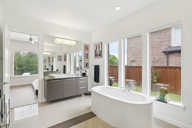 Full bath with vanity, a freestanding tub, tile patterned floors, a wall mounted air conditioner, and a ceiling fan | Image 13