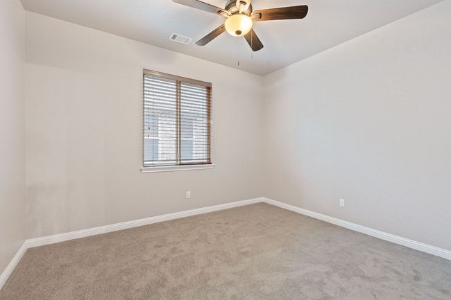 Carpeted room with blinds, baseboards and a ceiling fan | Image 26