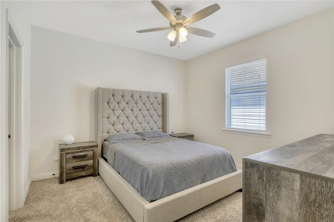 Bedroom featuring light colored carpet and a ceiling fan | Image 28