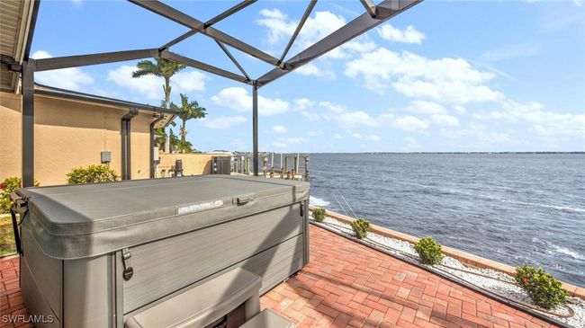 Pool area with a hot tub, a water view, a patio, and a lanai | Image 8