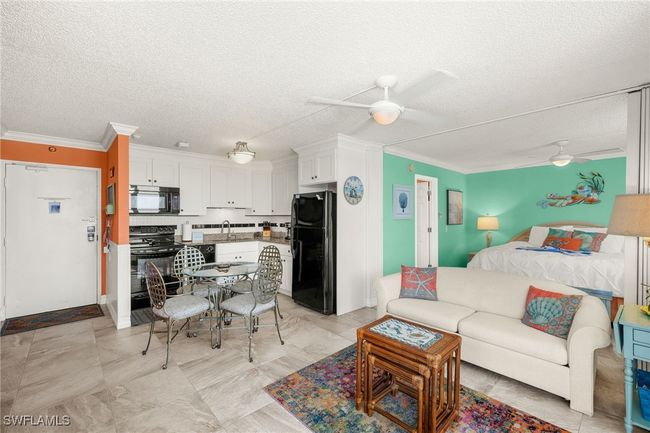 Living room featuring a ceiling fan, crown molding, and a textured ceiling | Image 4