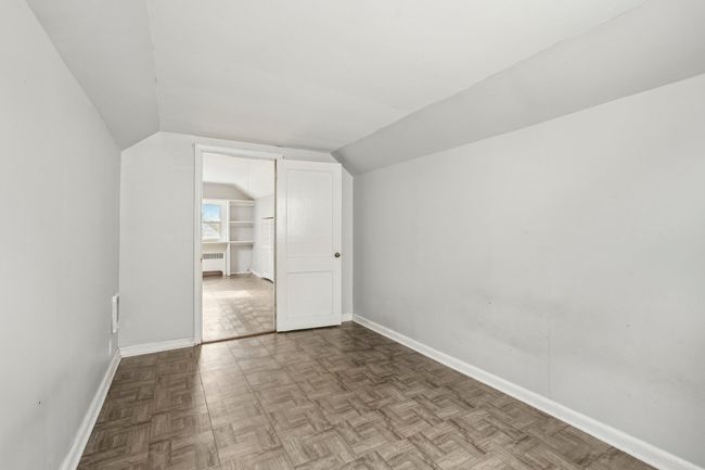 Additional living space with baseboards, radiator, and lofted ceiling | Image 18