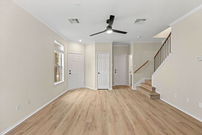 Foyer entrance featuring stairway, visible vents, light wood-type flooring, baseboards, and ceiling fan | Image 8