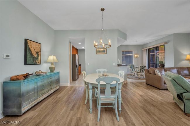 Dining area featuring a chandelier and light wood-style flooring | Image 7