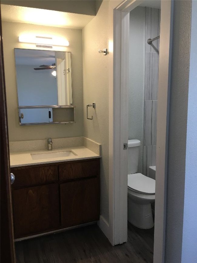Bathroom with toilet, wood finished floors, a shower, and vanity | Image 6