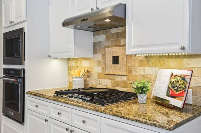 A remodeled kitchen designed to impress—with stainless steel appliances and sleek countertops. | Image 12