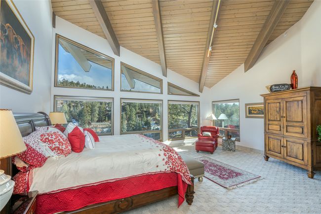 Carpeted bedroom featuring high vaulted ceiling, wooden ceiling, and beam ceiling | Image 19