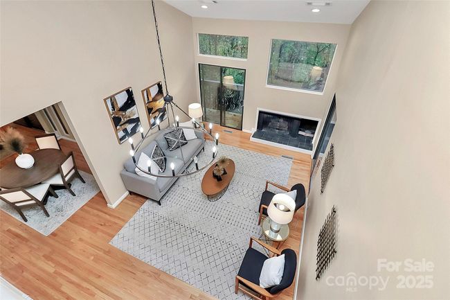 View from above! Soaring ceilings create the airy open feel, statement lighting and rich hardwood floors. As an end unit, this space is enhanced with extra windows and access to the private deck. | Image 10