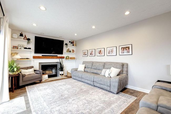 Family room with fireplace and tastefully updated shiplap wall and fireplace surround. | Image 9