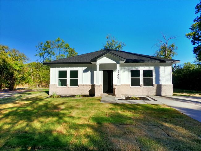 Bungalow-style house featuring board and batten siding, a shingled roof, brick siding, and a front yard | Image 16