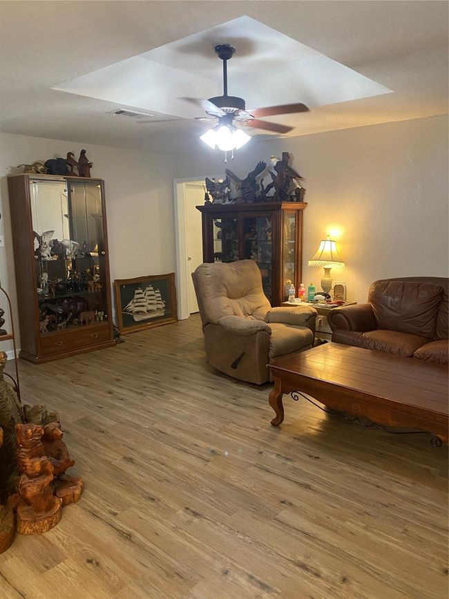 Living area featuring wood finished floors, visible vents, and a ceiling fan | Image 4