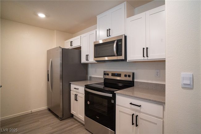 Kitchen featuring appliances with stainless steel finishes, white cabinetry, light wood finished floors, and recessed lighting | Image 7