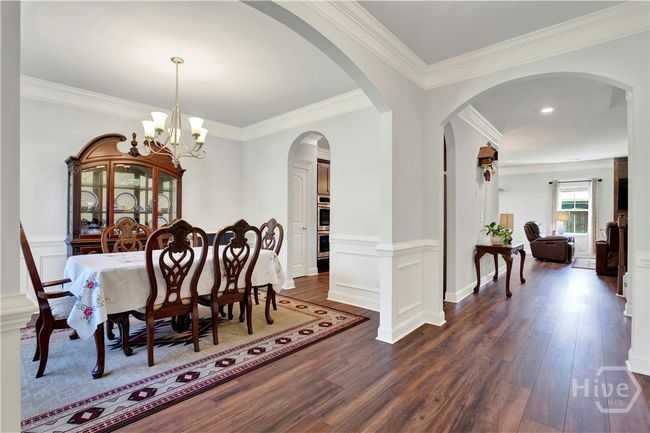 Foyer entrance to home with beautiful archways, ornate moldings and crown molding, wood-look luxury vinyl flooring | Image 9