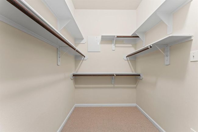 The spacious walk-in closet offers ample room for clothing, shoes, and accessories. Built-in shelving and double hanging rods make it easy to stay organized. | Image 28