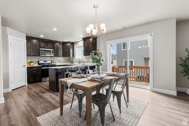 Dining space with a chandelier, light wood-style flooring, baseboards, and recessed lighting | Image 13