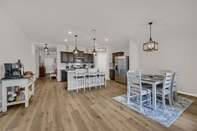 Dining space with light wood-type flooring, a chandelier, and recessed lighting | Image 9