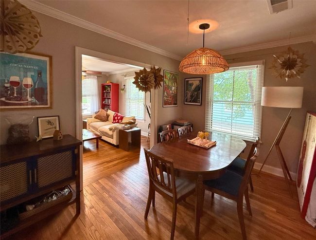 Dining space featuring wood-type flooring, ornamental molding, and plenty of natural light | Image 5
