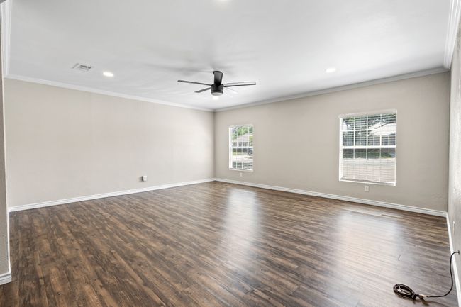 Spare room featuring ceiling fan, crown molding, dark wood-type flooring, baseboards, and recessed lighting | Image 13