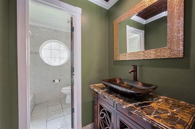 Upstairs Bathroom #3- with closed door access to allow for double access. Combo shower and tub in this full bathroom. Designer details including hammered copper vessel sink, dark marble countertop and coordinating framed mirror. | Image 38